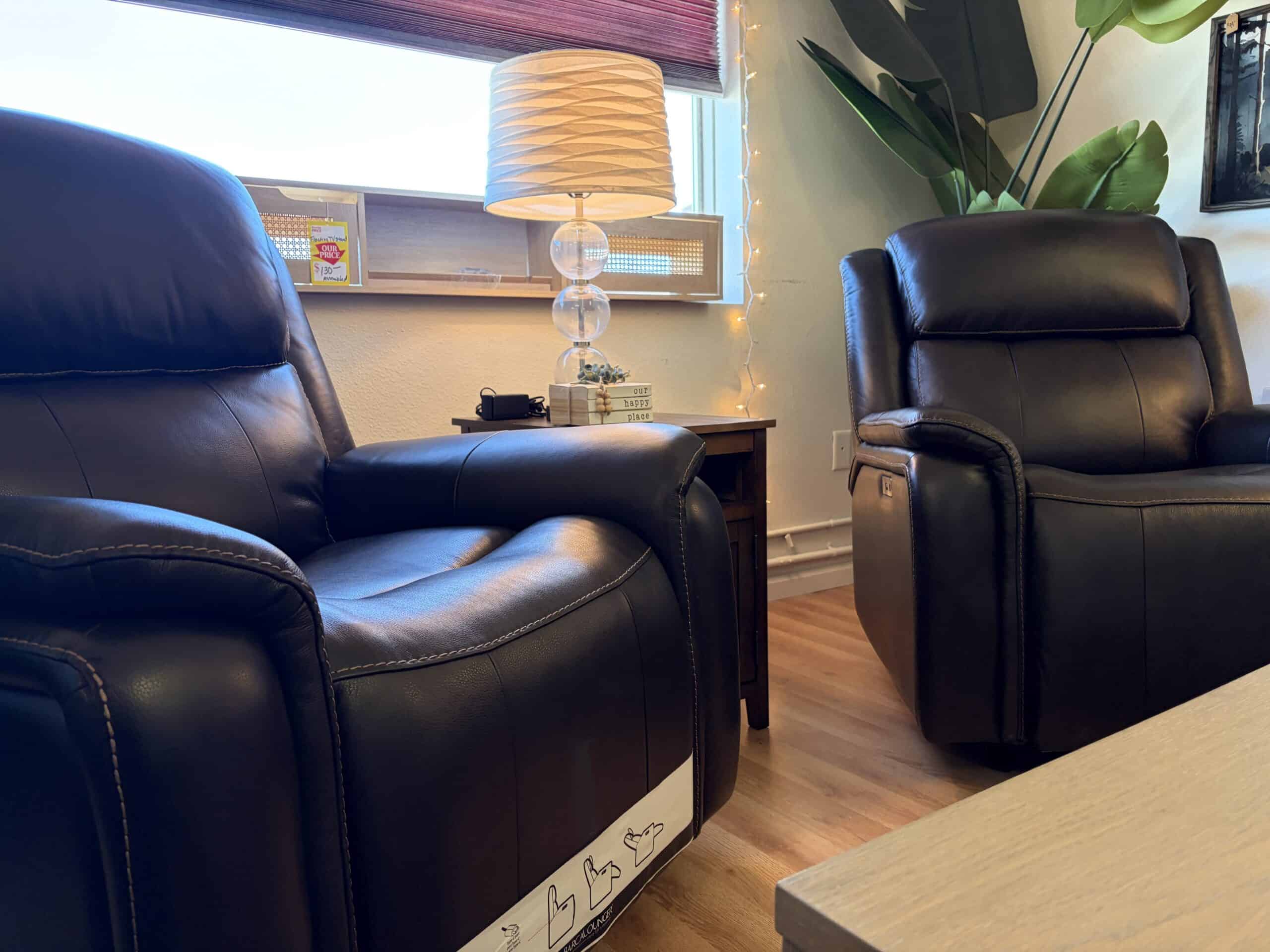 Two recliner sofas with nightstand and lamp